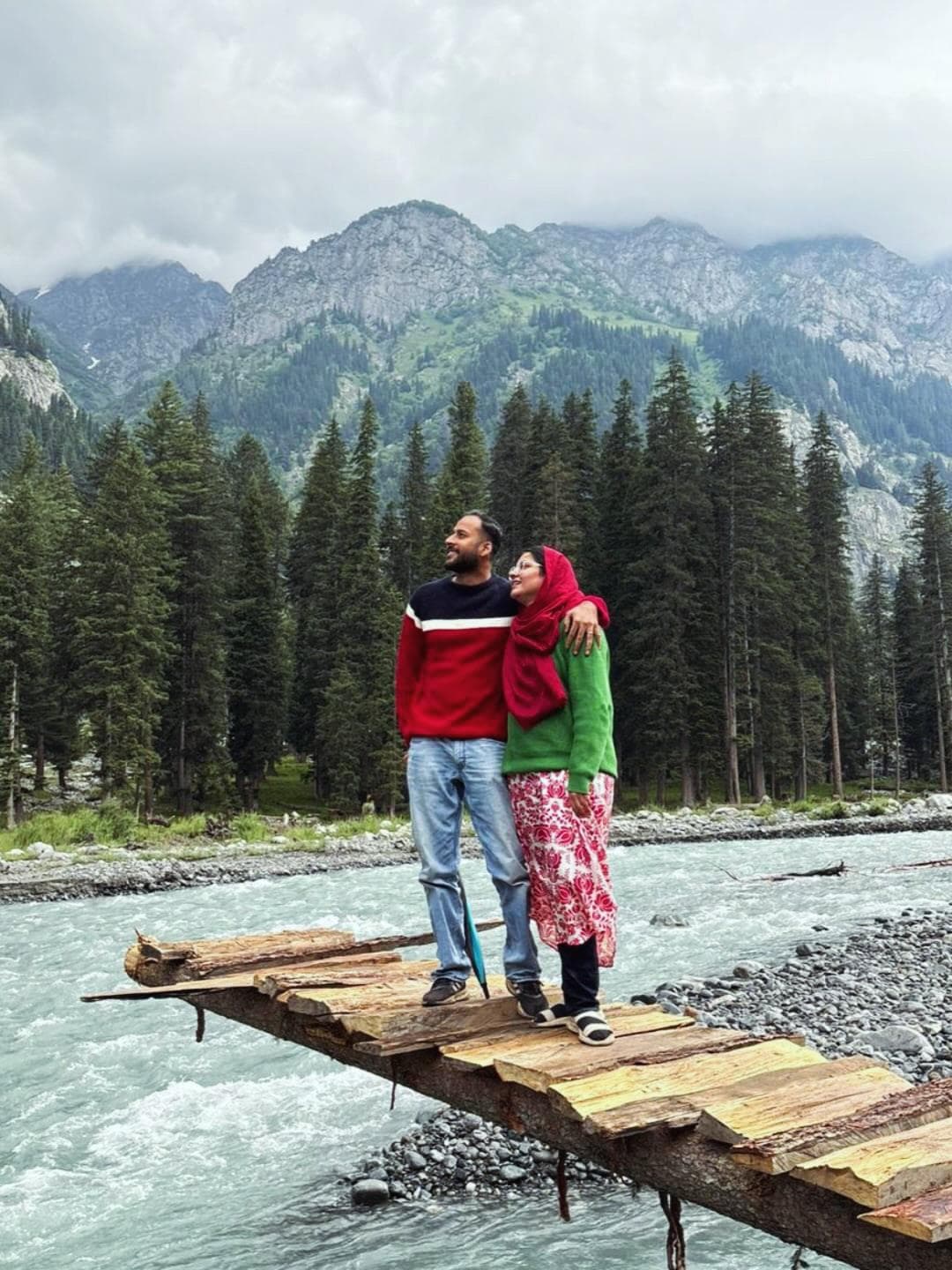Two travellers on a wooden bridge over the Panjkora river in Kumrat
